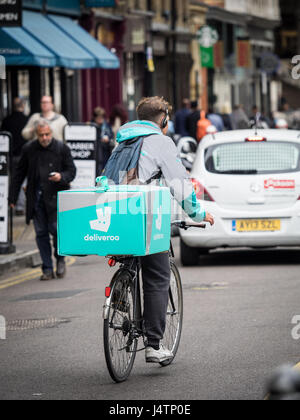 Un Deliveroo courier livraison de nourriture à travers les rues de Soho à Londres Banque D'Images