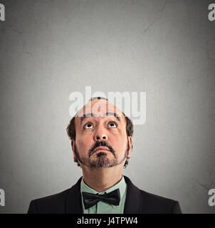 Closeup portrait portrait middle aged man looking up isolé sur fond de mur gris avec copie espace au-dessus de la tête. Visage humain expressions, émotions, fe Banque D'Images