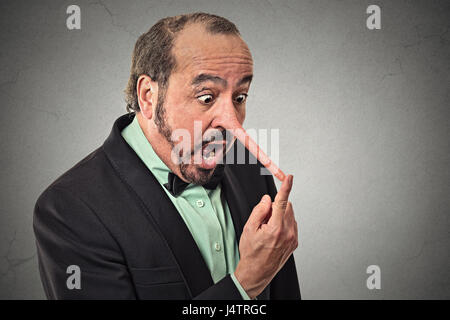 Homme avec long nez isolé sur fond de mur gris. Menteur concept. Visage humain expressions, émotions, sentiments. Banque D'Images
