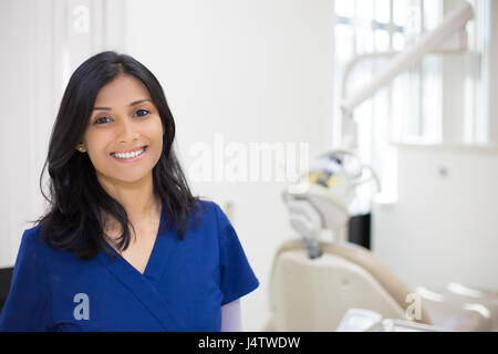 Closeup portrait portrait de friendly, joyeuse, smiling confident female, professionnel de la santé en bleu. l'arrière-plan de l'hôpital clinique isolé Banque D'Images