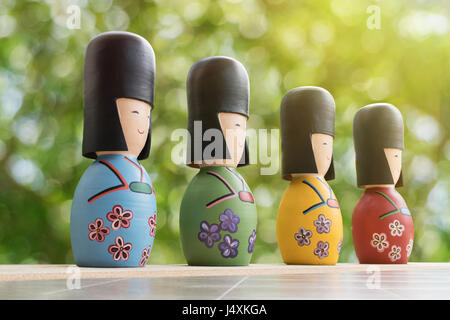 Poupées de Kokeshi japonaise avec green bokeh background Banque D'Images