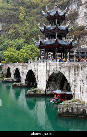 Zhenyuan, Guizhou, en Chine. Bateau de croisière en passant sous l'Zhusheng pont à travers le fleuve Wuyang. Banque D'Images