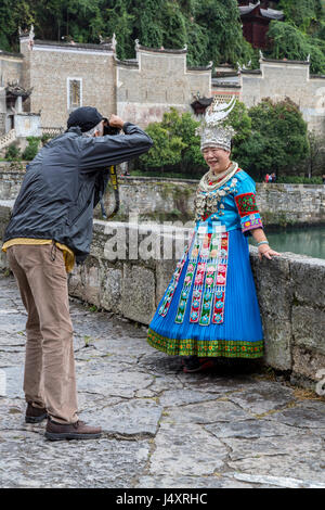 Zhenyuan, Guizhou, en Chine. Tourist Photographing Woman in traditional dress ethniques Miao. Banque D'Images