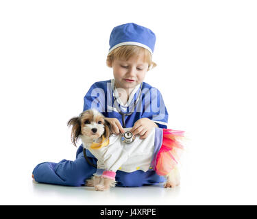 Petit garçon examinant puppy dog, isolé sur fond blanc Banque D'Images