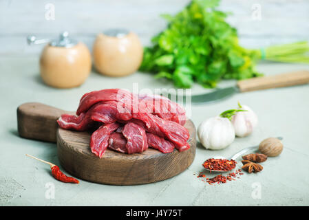 La viande crue sur planche de bois et sur une table Banque D'Images