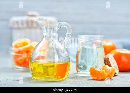 Mandarines huile dans le flacon en verre et sur une table Banque D'Images