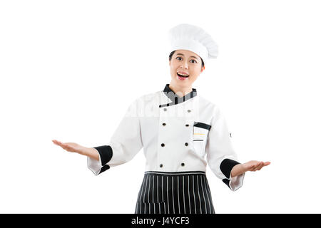 Heureux sourire femme chef ou cuisinier présentant montrant sa grande fête en face de l'appareil photo avec main ouverte. geste isolé sur fond blanc d'une profession. Banque D'Images