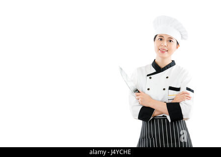 Jeune chef avec un couteau et montrant smiling standing sur un blanc copyspace avec mains croisées mur blanc isolé dans l'arrière-plan sont de la publicité Banque D'Images