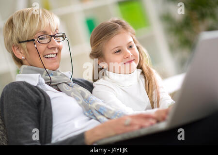 L'enseignement moderne grand-mère petit-enfant comment utiliser un ordinateur portable à la maison Banque D'Images