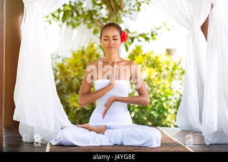 Young woman practicing yoga in Buda poser dans la nature sous baldaquin Banque D'Images