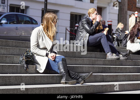 Londres, Royaume-Uni - 22 avril 2017 : Les gens sont assis sur les marches de la place Banque D'Images