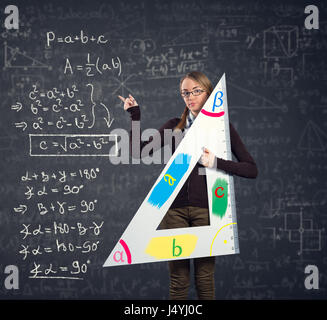 Étudiante avec une grande règle en montrant le théorème de Pythagore on blackboard Banque D'Images
