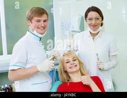 Happy female portrait professionnel de la santé assistant dentiste satisfait patient smiling woman in office giving Thumbs up sign geste. T réussi Banque D'Images