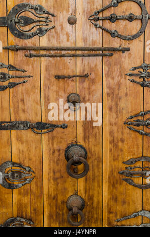 Porte en bois ancienne avec des raccords en métal, poignées et ornements au bâtiment historique dans la vieille ville arabe, Fès, Maroc. Banque D'Images