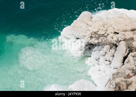 Donnant sur la mer Morte est l'eau vert émeraude et robuste, en croûte de sel banque. Les cristaux de sel blanche et beige sont inégales et rugueux. À partir de ci-dessus. Banque D'Images