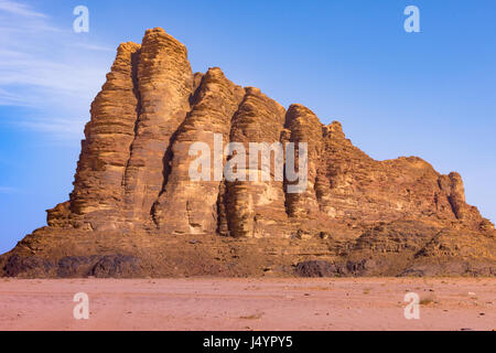 Les sept piliers de la sagesse, un boîtier robuste, Rocky Mountain dans le Wadi Rum, Jordanie. Sable Orange est au premier plan et de ciel bleu profond et les nuages minces au-dessus Banque D'Images