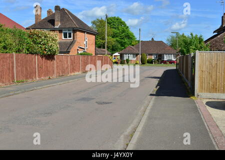 Une rue de banlieue à Surrey, en Angleterre par une chaude journée de printemps en mai. Banque D'Images