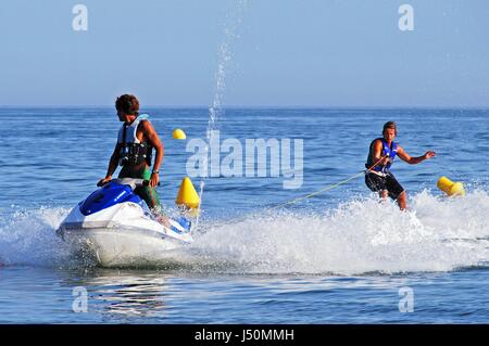 Man riding un jet ski remorquer une skieur, Marbella, Province de Malaga, Andalousie, Espagne, Europe de l'Ouest. Banque D'Images