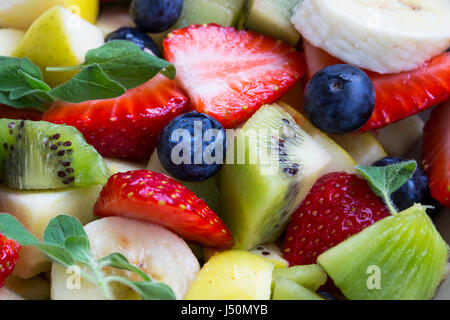 Salade de fruits sains colorée vue macro avec fraises, bleuets, pommes, kiwi et bananes Banque D'Images