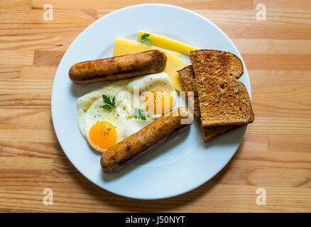 Deux œufs au plat avec des saucisses et du fromage cheddar et d'une rôtie de blé entier Banque D'Images