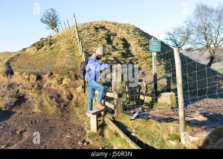 Une marchette négocier un style sur la promenade le long de la crête de Mam Tor. Banque D'Images