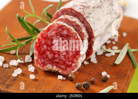 Salaison à sec français saucisse avec épices sur planche à découper en bois - close up Banque D'Images