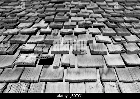 Une vue inclinée avec profondeur de champ de bardeaux de bois sur une vieille maison montrant les dommages qui ont eu lieu des années. Banque D'Images