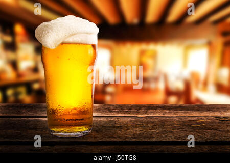 Verre de bière légère sur une table dans un pub Banque D'Images