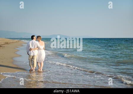 Happy romantic couple embrassé la marche sur la plage, près de la mer Banque D'Images