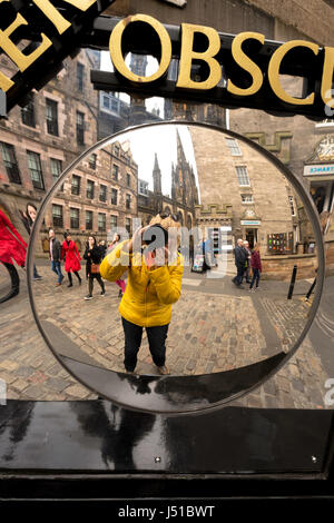 Femme photographe prenant un auto-portrait dans un miroir déformant l'extérieur Camera Obscura & World of Illusions, Edinburgh, Lothian, Scotland, UK. Banque D'Images