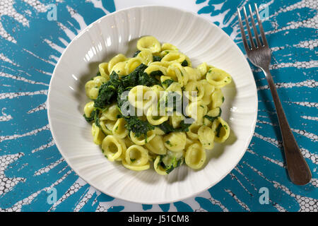 Les feuilles de navet (chou vert) (pâtes orecchiette alle cime di italien rapa) servi dans un plat blanc sur blanc et bleu clair - napperon ci-dessus Direct Banque D'Images