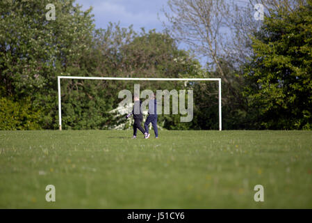 Blairdardie Park keal avenue deux jeunes garçons marchant dans le football terrain de football herbe verte amitié d'enfance Banque D'Images