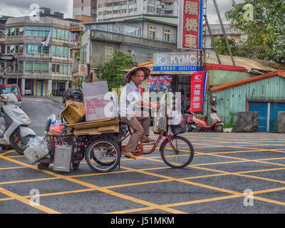 Stanley, Taiwan - le 18 octobre 2016 : l'homme taiwanais avec différents éléments sur un vélo à trois roues. Les tricycles sont très populaires les moyens de transport Banque D'Images