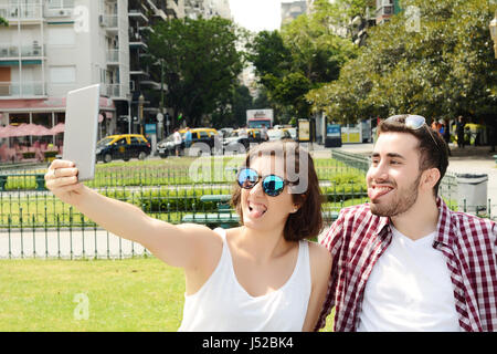 Portrait d'un jeune beau couple avec selfies digital tablet. À l'extérieur. Banque D'Images