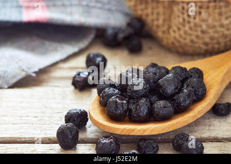 Aronia séchées baies (chokeberries) dans une cuillère de bois. Copy space Banque D'Images