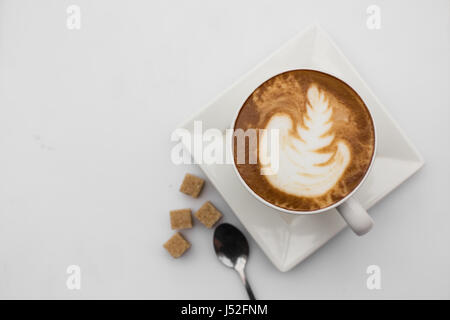 Vue de dessus de café tasse sur fond blanc. Tasse de cappuccino vue d'en haut. Mise à plat. Copy space Banque D'Images
