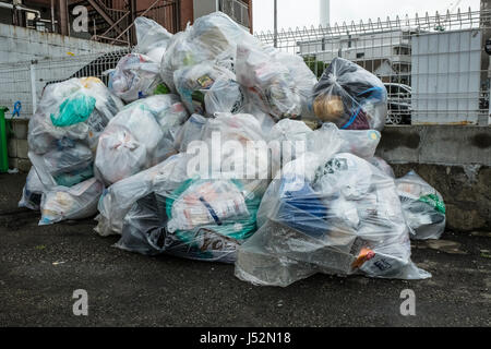 Sacs poubelles en plastique dans un parking en attente d'être recueillis à Tokyo Banque D'Images