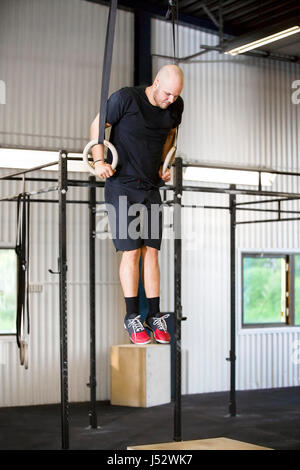 Déterminé à l'aide de bagues de l'Athlète masculin de la gymnastique dans un club de santé Banque D'Images