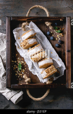 Jeu de glace maison sandwiches dans les cookies d'avoine avec du sucre d'amande grillée sur du papier sulfurisé en bac sur woden dark metal texture background. Haut de la vie Banque D'Images