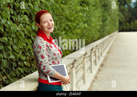 Portrait of a woman with tablet computer sur l'arrière-plan de feuilles vertes Banque D'Images