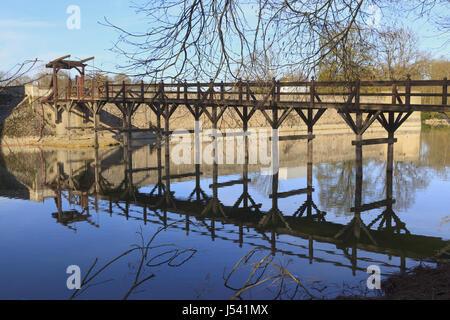 Pont-levis en bois se reflétant dans les douves du château de Sully, France Banque D'Images