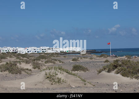 Le drapeau rouge pèse dans le vent à Surfers Beach Famara sur Lanzarote. Banque D'Images