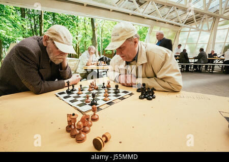 Biélorussie, MINSK - 9 mai 2014 : les retraités actifs, de vieux amis et de temps libre, les hommes âgés s'amuser et jouer aux échecs au city park. Banque D'Images