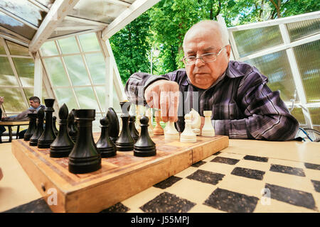 Biélorussie, MINSK - 9 mai 2014 : les retraités actifs, de vieux amis et de temps libre, les hommes âgés s'amuser et jouer aux échecs au city park. Banque D'Images