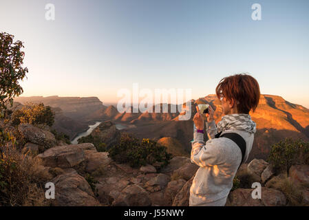 Blyde River Canyon, célèbre destination de voyage en Afrique du Sud. Les touristes à la recherche du panorama avec des jumelles. Dernière lumière du soleil sur les crêtes des montagnes. Pêches Banque D'Images