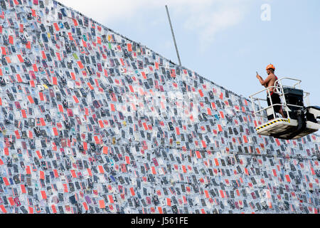 Kassel, Allemagne. 15 mai, 2017. dpatop - Un employé prend des photos de books enveloppé dans du plastique sur le cadre en acier de la documenta d'art 'Le Parthénon de livres" par l'artiste Argentine Marta Minujin, qui est en construction à Kassel, Allemagne, 15 mai 2017 à Kassel documenta 14. se déroule du 10 juin 2017 au 17 septembre 2017 Photo : Swen Pförtner/dpa/Alamy Live News Banque D'Images