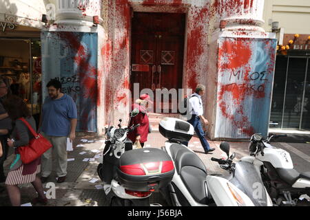 Thessaloniki, Grèce, 17 mai 2017. Les gens walkspass les bureaux de la Chambre de Commerce grecque et de l'industrie barbouillé de peinture rouge par les manifestants. Plusieurs milliers de Grecs sont descendus dans la rue dans le cadre d'une grève générale de 24 heures par les syndicats pour protester contre une nouvelle série de mesures d'austérité le gouvernement grec a accepté avec son creditos . Credit : Orhan Tsolak / Alamy Live News Banque D'Images