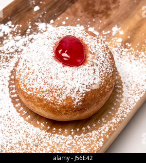 Sufganiyah (sufganiyot) un juif traditionnel Donut mangé pendant Hanoucca avec confiture rouge et le sucre en poudre. Sur fond blanc Banque D'Images