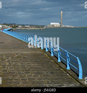 Garde-corps bleu sur le front de mer de Carrickfergus, (Kilroot Power Station dans la distance). Banque D'Images