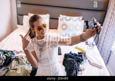 Diffusion d'enregistrement vlogger femelle avec un appareil photo numérique. Une femme qui l'affichage vidéo selfies vêtements mode et bijoux. Banque D'Images